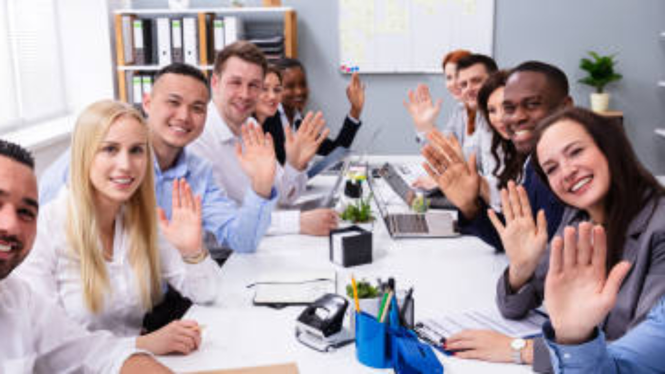 Happy Business Group Of Diverse People Waving Hands During A Meeting Conference In The Office