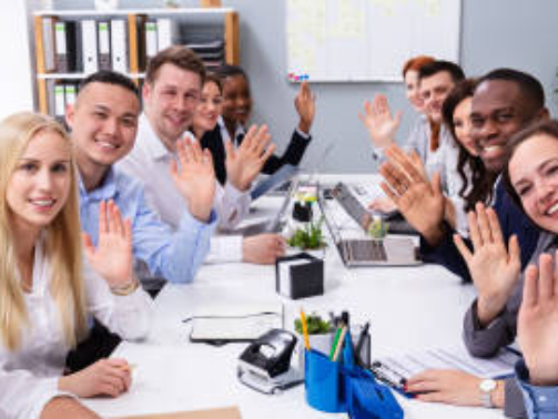 Happy Business Group Of Diverse People Waving Hands During A Meeting Conference In The Office